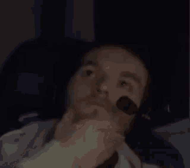 a man wearing headphones is sitting in a chair holding a microphone .