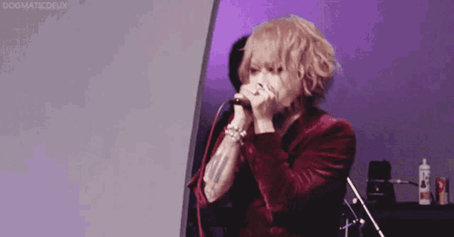 a person singing into a microphone with the word dogmaticdeux visible