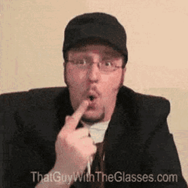 a man wearing glasses and a hat with the website thatguywiththeglasses.com
