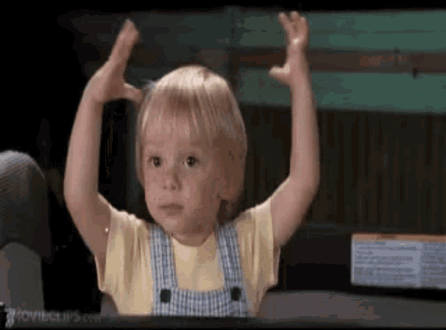 a little boy with his arms in the air .
