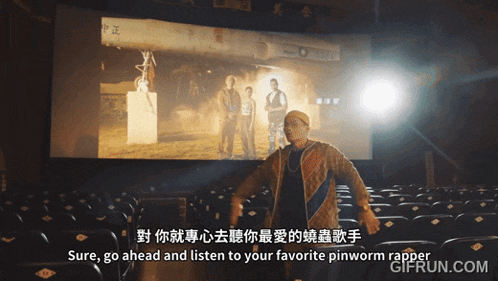 a man stands in front of a screen that says pinworm rapper