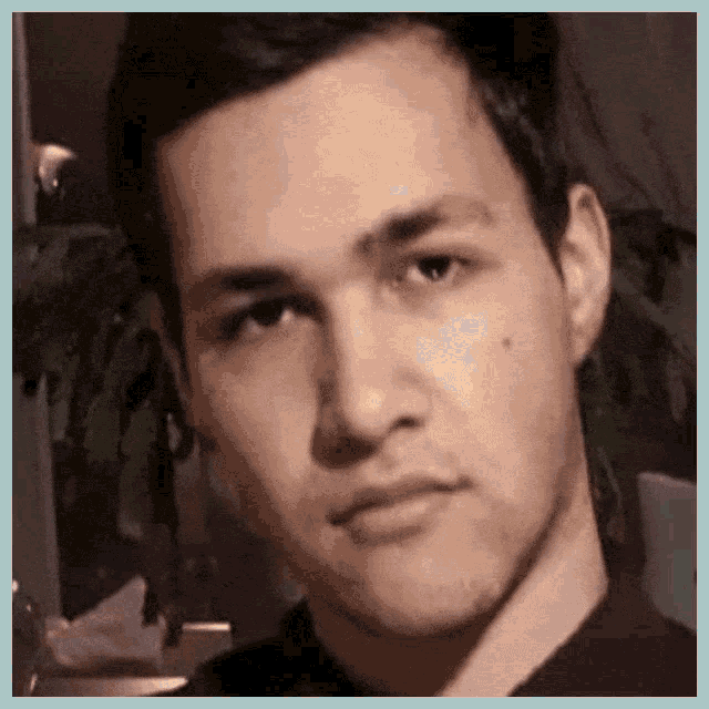 a close up of a man 's face looking at the camera