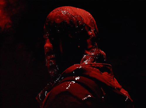 a person with a hood that is covered in red paint