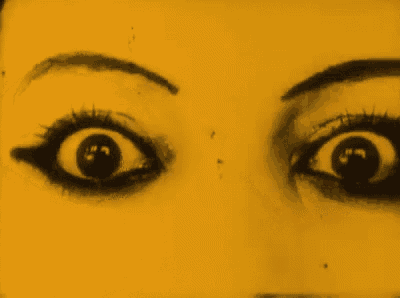 a close up of a woman 's eyes with a yellow background
