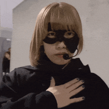 a woman wearing a black mask with a microphone on her head