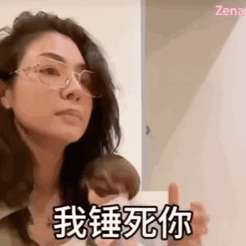 a woman wearing glasses is holding a doll in her hand .
