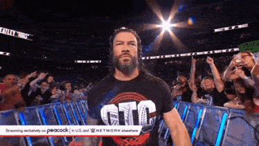 a wrestler wearing a shirt that says gtc walks through a crowd