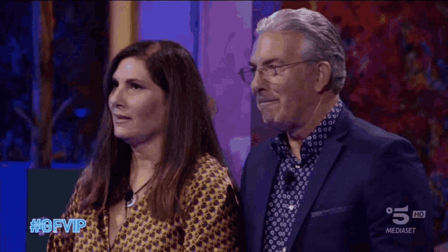 a man and a woman are sitting next to each other in front of a sign that says #gfvip on it