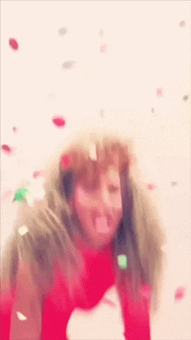 a woman wearing a red scarf is surrounded by confetti falling from the sky