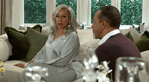 a man and a woman are sitting on a couch and talking to each other