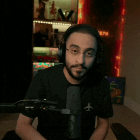 a man wearing headphones is sitting in front of a microphone with an airplane on his shirt