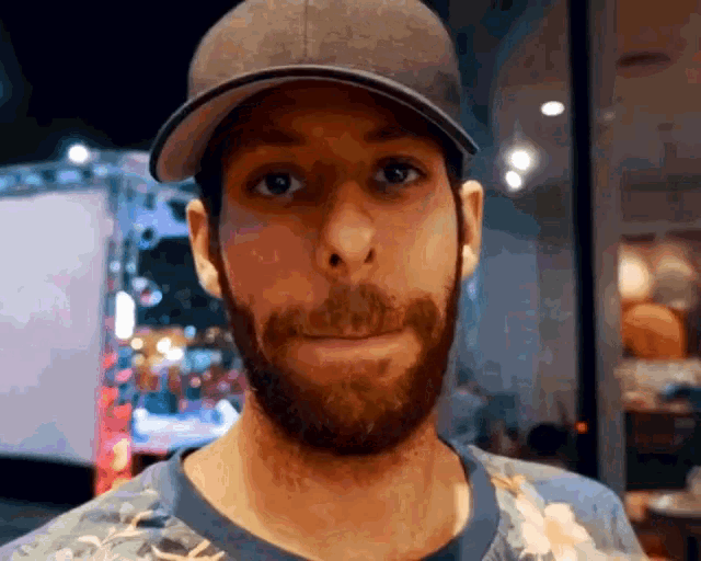 a man with a beard is wearing a hat