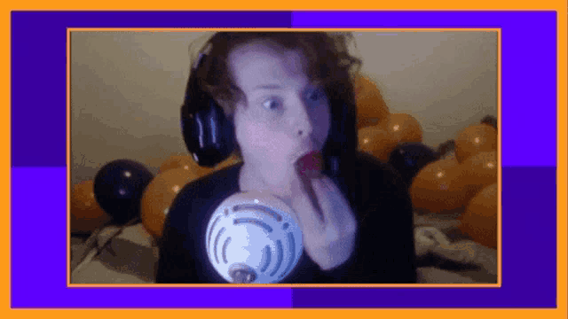 a person wearing headphones is holding a microphone in their mouth .