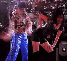 a man and a woman are dancing on a stage with the word n4ty on the bottom
