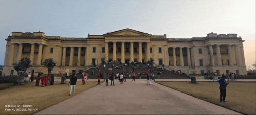 a group of people are walking in front of a large building that says ' iqoo 7 ' on it