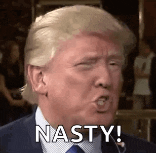donald trump is wearing a suit and tie and making a funny face while talking into a microphone .