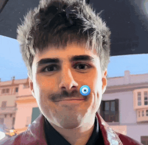 a man with a mustache has a blue eye on his nose