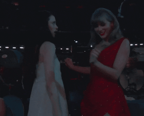 two women in red and white dresses are dancing together