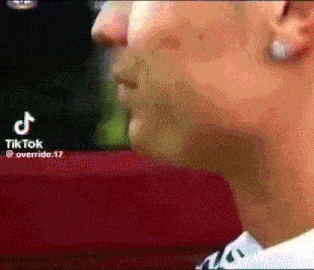 a close up of a man 's face with a red background and a tik tok logo in the corner .