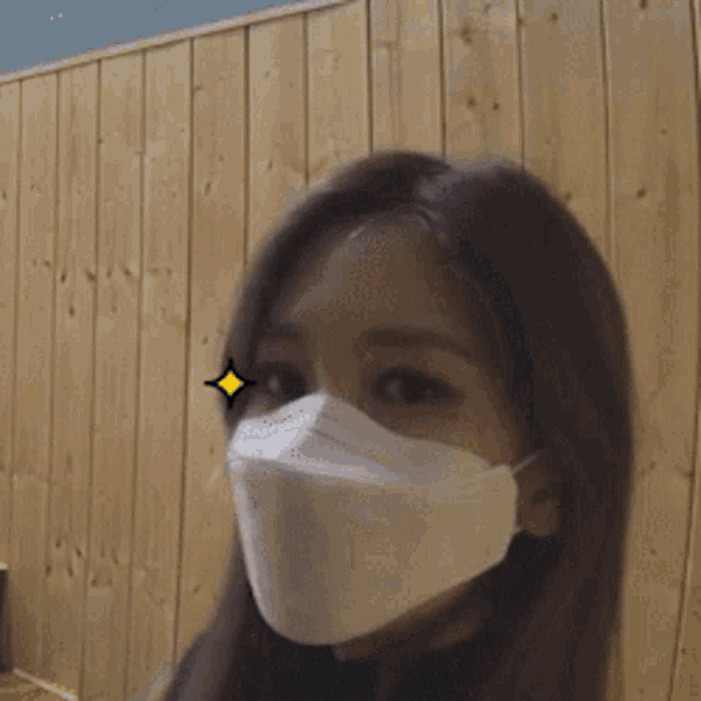 a woman wearing a face mask with a yellow star on her eyes
