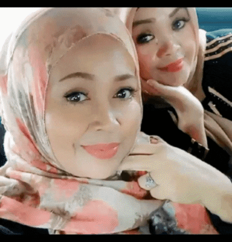 two women wearing hijabs are sitting next to each other in a car and smiling .