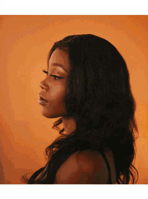 a woman with long black hair looks to the side