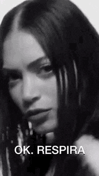 a black and white photo of a woman with long hair and the words `` ok . respira '' written on the bottom .