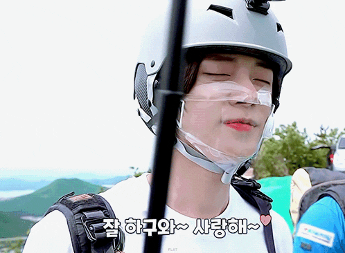 a man wearing a helmet with a clear mask on his face says " i love you " in korean