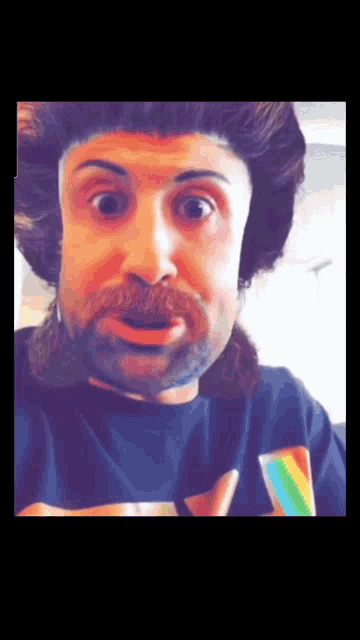 a man with a mustache and a wig is wearing a shirt with a rainbow on it