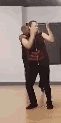 a man is dancing with another man in a room .