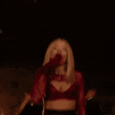 a woman in a red and black outfit is dancing