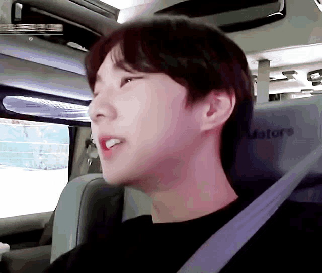 a young man is sitting in the back seat of a motors van