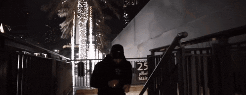 a person is walking down stairs with a sign that says 25 on it