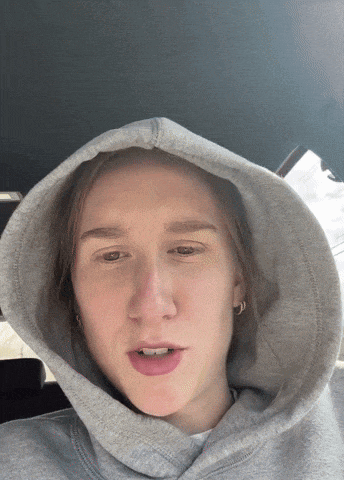 a person wearing a grey hoodie with a hood