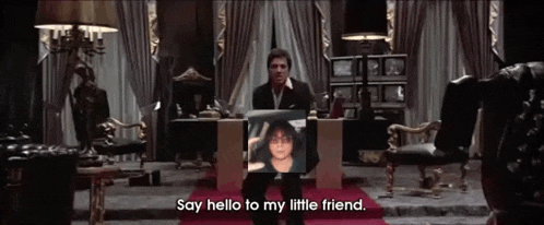 a man sitting at a desk with a picture of a woman on it and the words say hello to my little friend below him