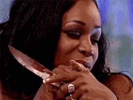 a woman with a ring on her finger is holding a knife