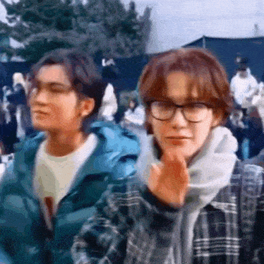 a man wearing glasses and a scarf is standing next to a woman wearing glasses and a scarf .