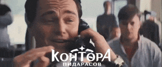 a man is crying while talking on a cell phone in a crowded room .