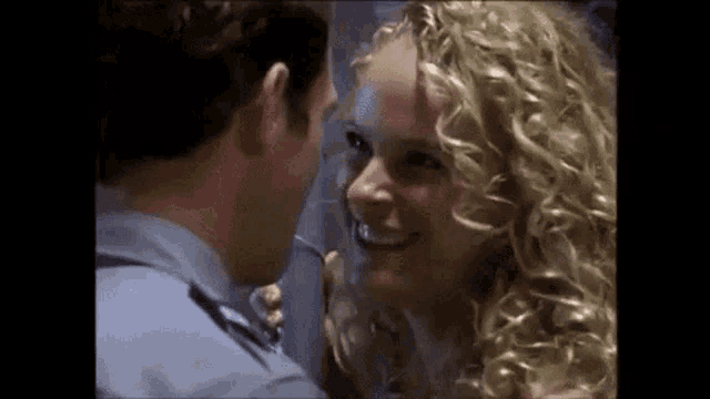 a man and woman are looking at each other and smiling .