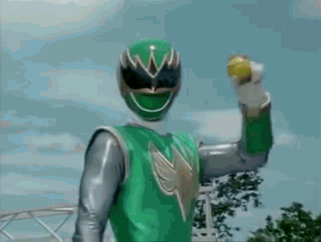a green power ranger holding a yellow object in his hand
