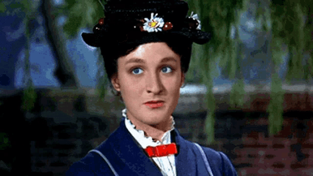 a woman wearing a black hat with flowers on it