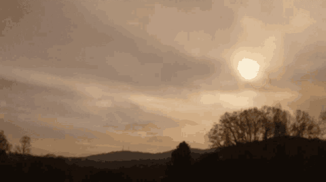 the sun is shining through the clouds above the mountains