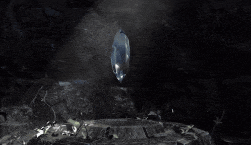 a large crystal is floating in a dark cave