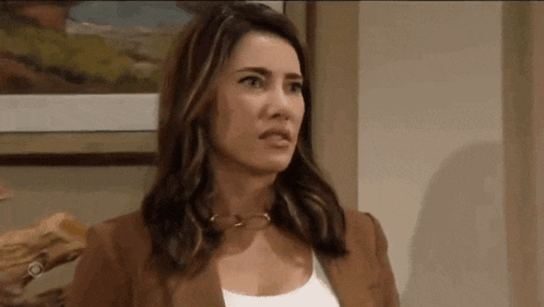 a woman is standing in front of a painting and making a funny face .