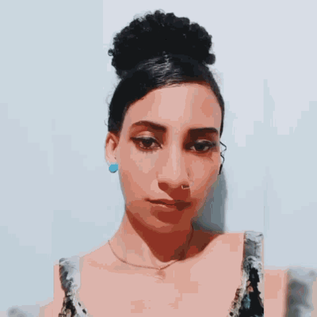 a woman with a nose ring and earrings looks at the camera