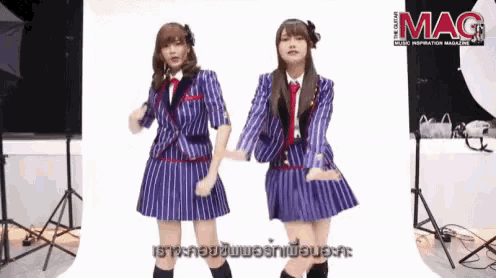two girls are dancing in front of a mag magazine