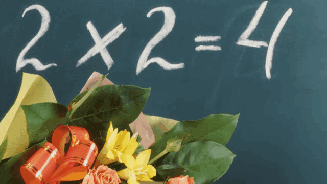 a bouquet of flowers sits in front of a blackboard with 2x2 = 4 written in chalk