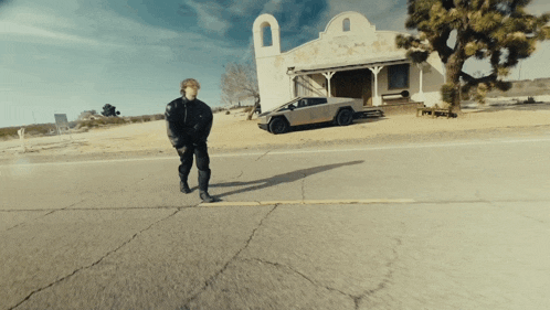a man walking down a street with a car parked in front of him