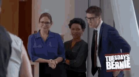 a group of people standing next to each other with a sign that says tuesday 's bernie