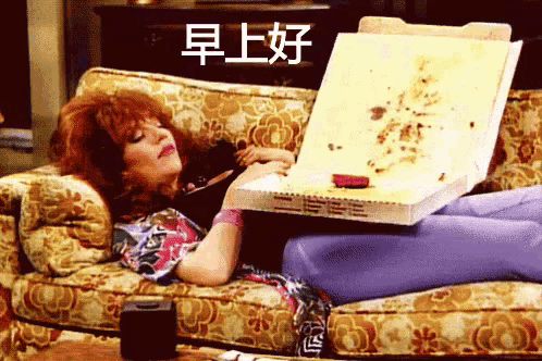 a woman is laying on a couch holding a pizza box with chinese writing on it